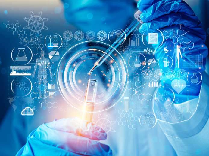 Scientist adding a drop of liquid to a test tube with virtual scientific icons and data graphics floating in the foreground.